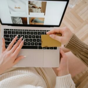 Person shopping online using a laptop and credit card, highlighting e-commerce convenience.